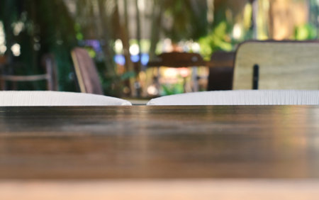 blurred background, empty wooden table in front of restaurant.