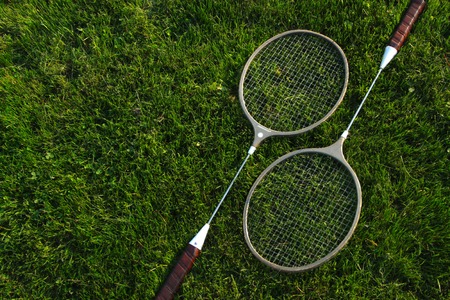 badminton rackets resting upon green grassの写真素材