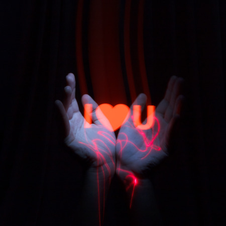 Light Painting Photography. Freezelight photo. Hands holding a red glowing massage with freezelight effect.の写真素材