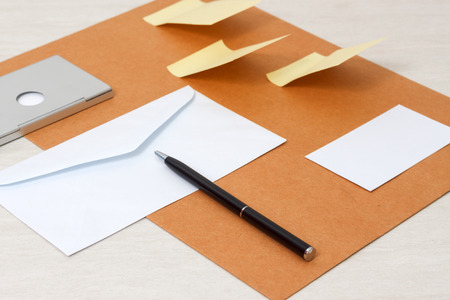 A set of blank envelopes, sticky notes, business card and pen side viewの写真素材