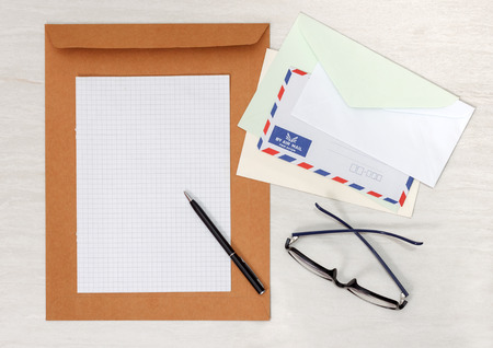 A set of blank envelopes with paper, pen and glassesの写真素材