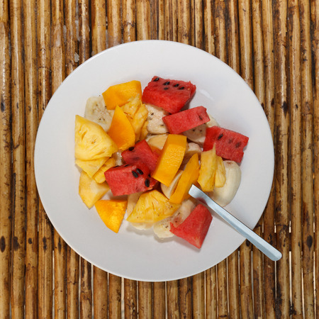 Natural light photo of different fruit mix salad on white plate top view 1の写真素材