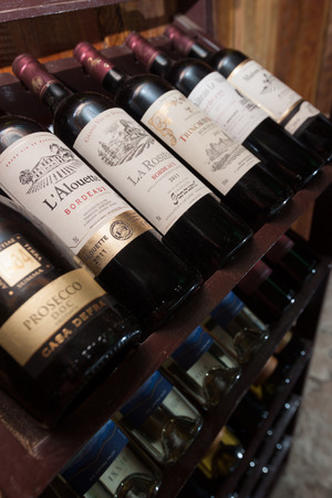 SIHANOUKVILLE, CAMBODIA - MARCH 06, 2015: European traditional shelves with wine bottles in Otres beach bar in Sihanoukville, Cambodia. Closeup photo with shallow DOF  のeditorial素材