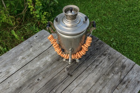 russian samovar on a rustic wooden table in the gardenの写真素材