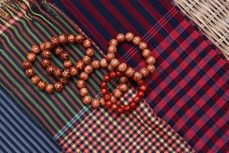 Colorful traditional khmer scarfs and buddish beads top view closeupの写真素材