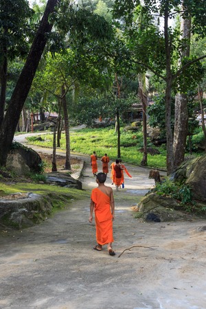 SIHANOUKVILLE, CAMBODIA - JUNE 26, 2015: group of young southeast asian buddhist monks walk in park in temple Wat Krom in Sihonoukville, Cambodia on June 26, 2015.のeditorial素材