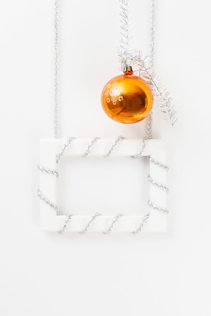 New Year and Christmas greeting card template made of white frame with silver tinsel and orange ball view2の写真素材