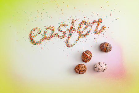 Easter lettering made from colorful baking sugar and colorful hand drawn eggs over colorful background with copy space, horizontal top viewの写真素材