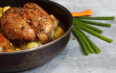 Raw chicken meat in marinade with vegetables in frying pan ready for cooking, close up with...