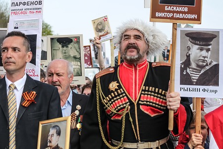 ULYANOVSK, RUSSIA - MAY 9, 2016: Man in Cossack military uniform holds portrait of relatives at Immortal regiment on 9 May, 2016 in Ulyanovsk, Russiaのeditorial素材