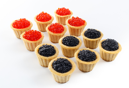 Tartlets filled with red and black caviar against white background, close up, horizontal viewの写真素材