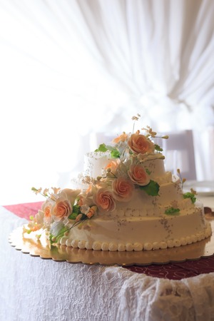 Close up of beautiful white wedding cake decorated with sweet rosesの写真素材