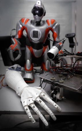 Close up of robot hand on table with another robot and details at background, concept of future technologyの写真素材