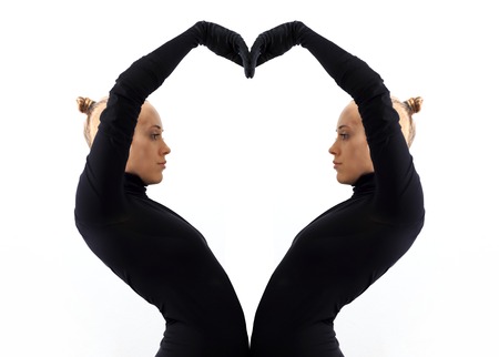 Creative concept, heart, symbol of love, fromed by two female bodies mirroring each other, horizontal view isolated on white backgroundの写真素材