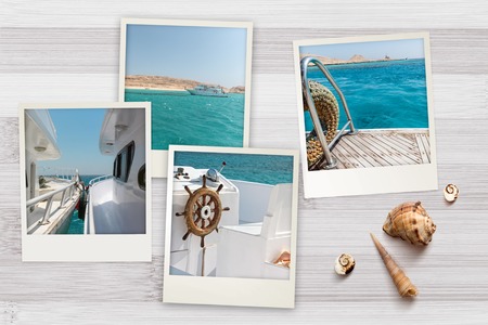 Beautiful seaside snapshots of instant camera arranged on rustic wooden background with seashells with copy space, top view. Summer vacation and voyage conceptの写真素材