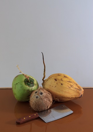 three different coconuts with machete on table with copy spaceの写真素材