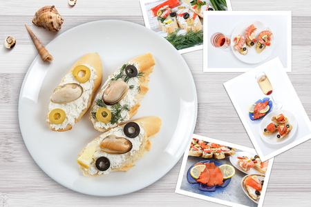 Beautiful snapshots of various italian sandwiches with seafood arranged on rustic wooden background with plates with food and seashells, with copy space, horizontal top view.の写真素材