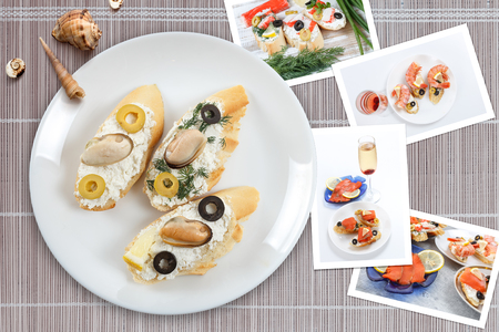 Beautiful snapshots of various italian sandwiches with seafood arranged on bamboo mat background with plates with food and seashells, with copy space, horizontal top view.の写真素材