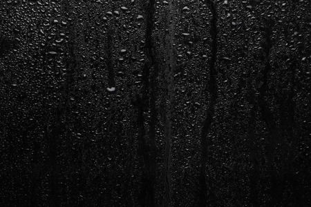 Part of series. Background photo of rain drops on dark glass, different size: small medium and large horizontal viewの写真素材