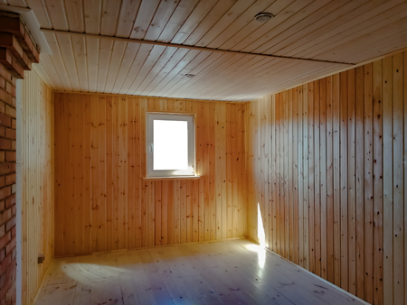 Empty new living room in a wooden countryhouse. Wooden walls and parquet flooringの写真素材
