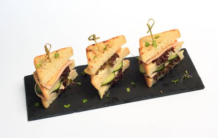 triangle club sandwich tripple set on black ceramic plate part of seriesの写真素材