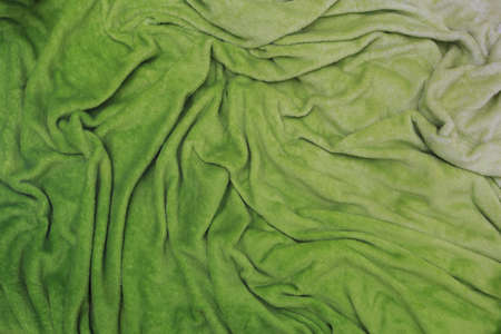 Lime-green soft wrinkled plush, draped velour background with draperyの写真素材