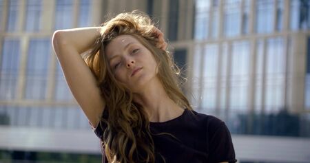 pretty teen woman is flirting with camera in urban landscape in summer day