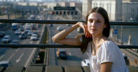 attractive girl in white top holds hand on trestle handrailsの写真素材