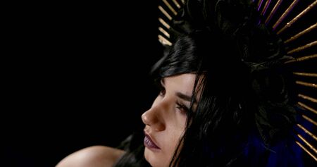 Close-up portrait of a girl at a masquerade as the virgin Mary on a black background