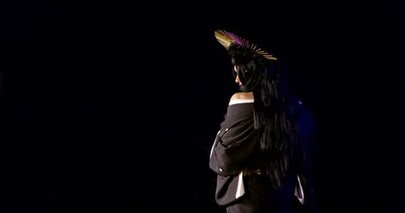 attractive girl with long dark hair, black rose spiked flower crown and kimono is posingの写真素材