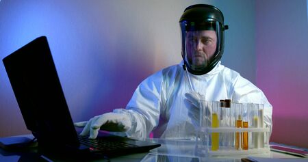 Scientist analyzing cloudy white liquid in test tubes, developing an antidote to virusesの写真素材