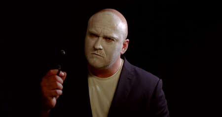 bald actor with mask plays angry character holding weaponの写真素材