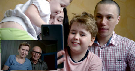 Parents with children communicate online in a virtual app using a webcam, enjoying a lifestyle...