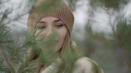 portrait of beautiful woman in forest, viewing on branch of pinesの写真素材