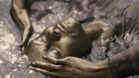a woman with dyed gold skin and hair lies in the water in a slow motion. He strokes his face.