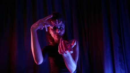 alluring young lady with fashion makeup is dancing in dark at home partyの写真素材