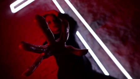 demonic woman dressed black clothes is dancing in church against lighting cross on wall
