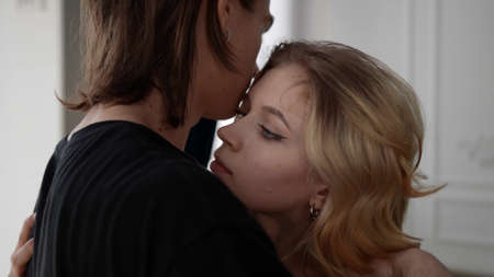 lovers are embracing after long separation, portrait of blonde lady and young man hugging each other