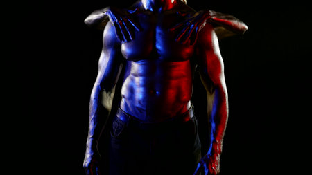 woman is stroking sexy washboard abs and muscular chest of attractive man in darknessの写真素材