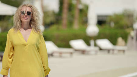 charming blonde woman with sunglasses is resting in hotel in summer vacationの写真素材