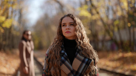 breakup and finish of romance in autumn day, woman is going away from her boyfriendの写真素材