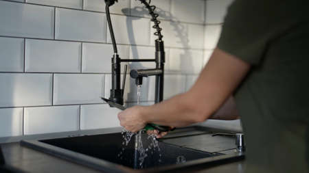 dishwashing in modern kitchen, housewife is using sponge and dishwashing detergentの写真素材