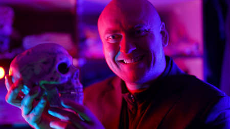 mysterious madman with human skull in hands, craziness and witchcraft, portrait