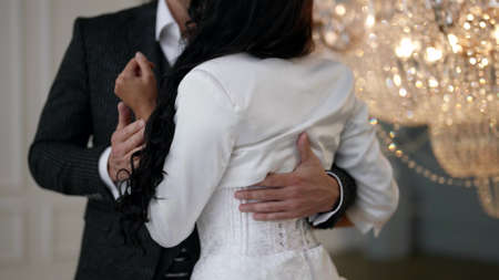 groom is hugging and kissing his slender young bride in wedding day, ceremony in luxury palaceの写真素材