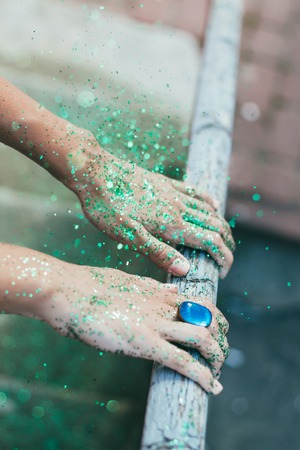 Green glitter on hands yong beautiful women