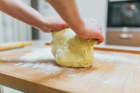 Making dough by female hands at bakery cakesの写真素材
