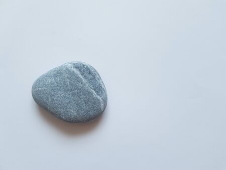A gray stone lies on a white backgroundの写真素材
