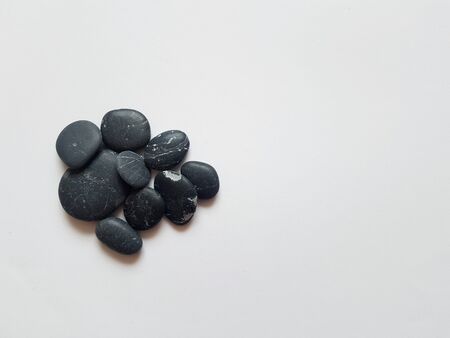 black stones are mixed together on a white backgroundの写真素材