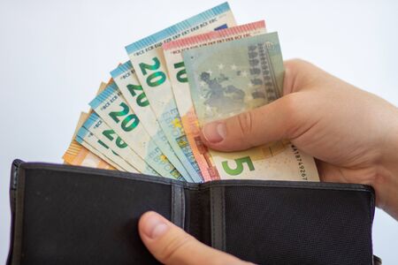 Pay in euros. Get euros from your wallet. Euro bills on a white background with a walletの写真素材