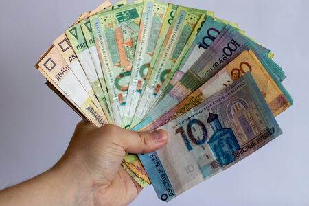 Hands with Belarusian money on a white background. Belarusian currency on a white background